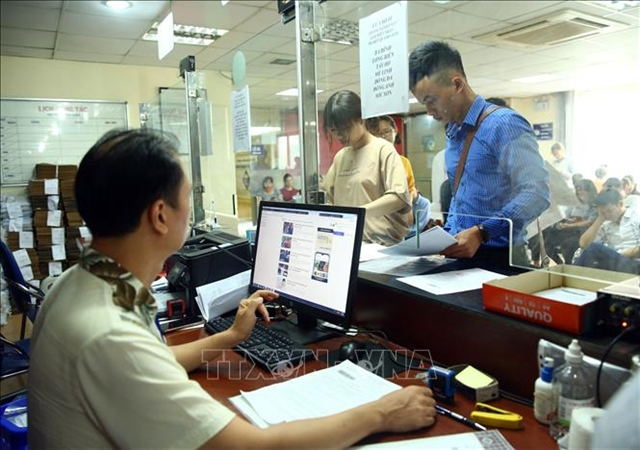 People complete procedures for establishing a business at the Hà Nội Department of Planning and Investment’s Business Registration Office.
